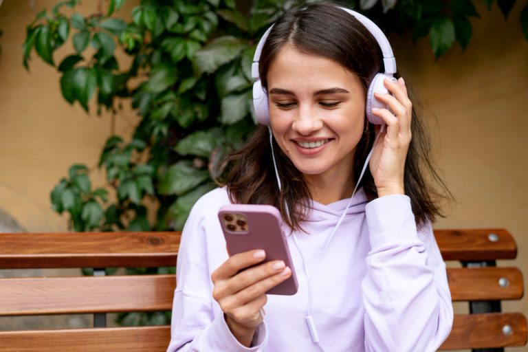 Joven escuchando música con audífonos y su celular
